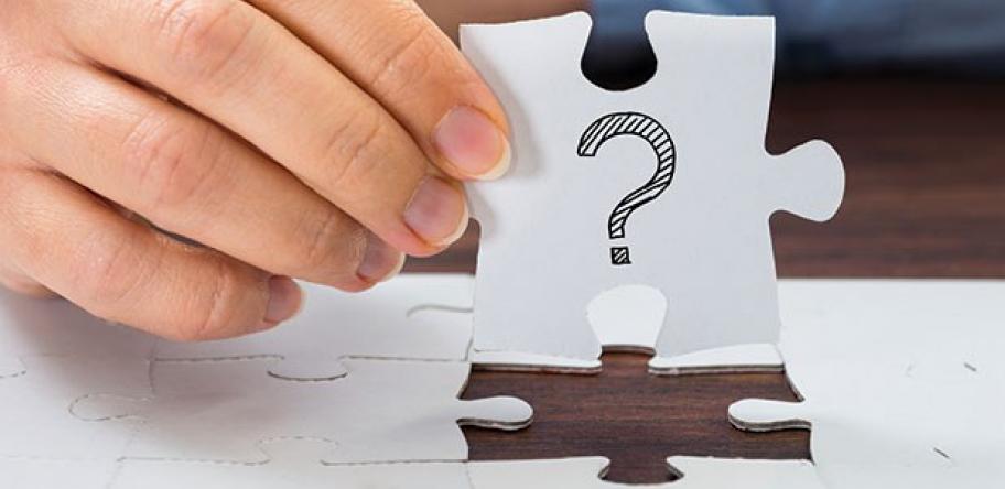 man holding jigsaw puzzle with question mark on it