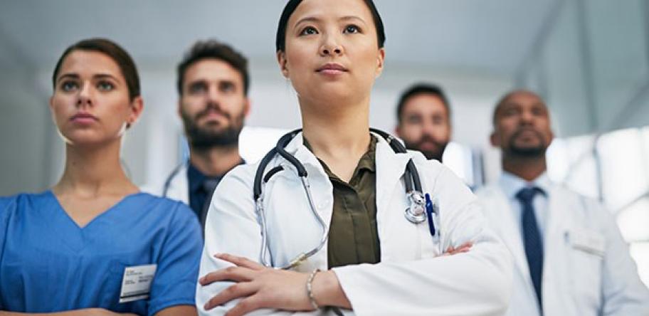 young female hospital doctor with other doctors behind
